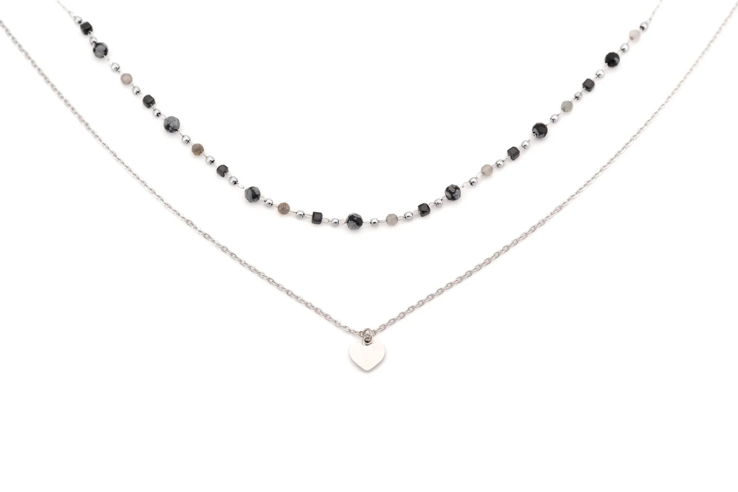 Layered necklace with black and silver beads and a silver heart pendant on white background