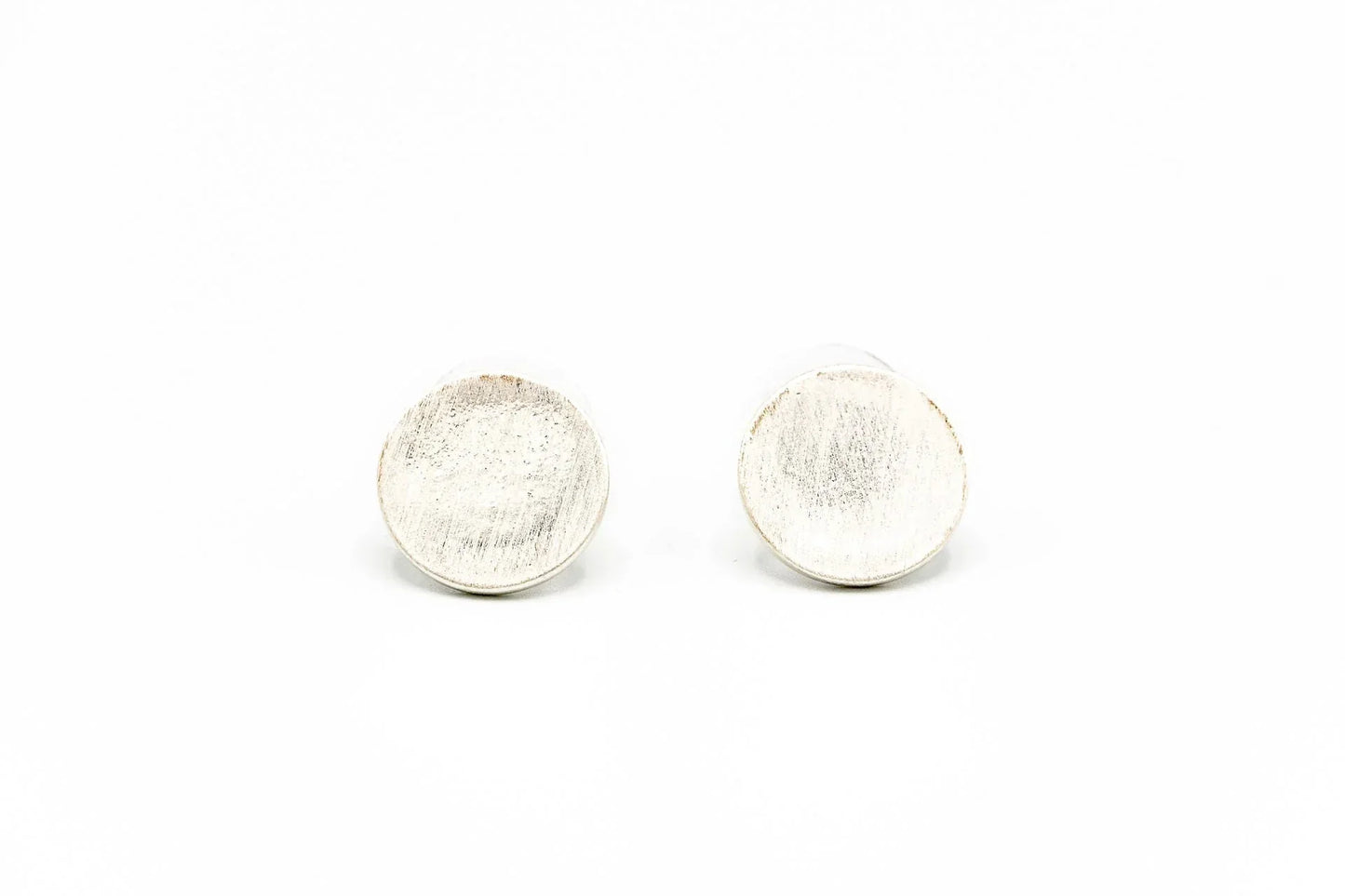 Round brushed silver stud earrings on white background