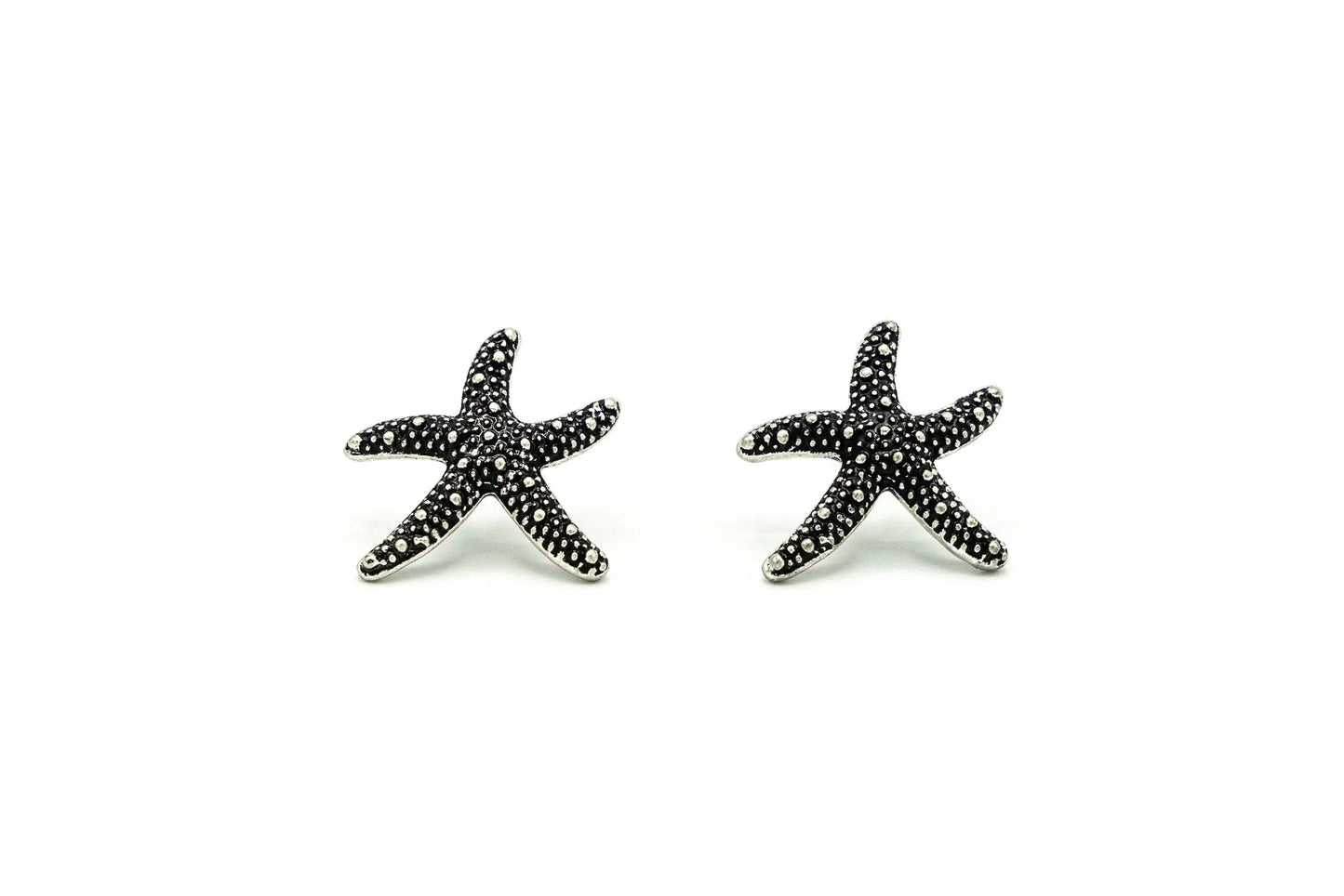 Pair of silver starfish stud earrings with textured dotted design on white background