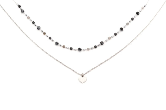 Layered necklace with black and silver beads and a silver heart pendant on white background