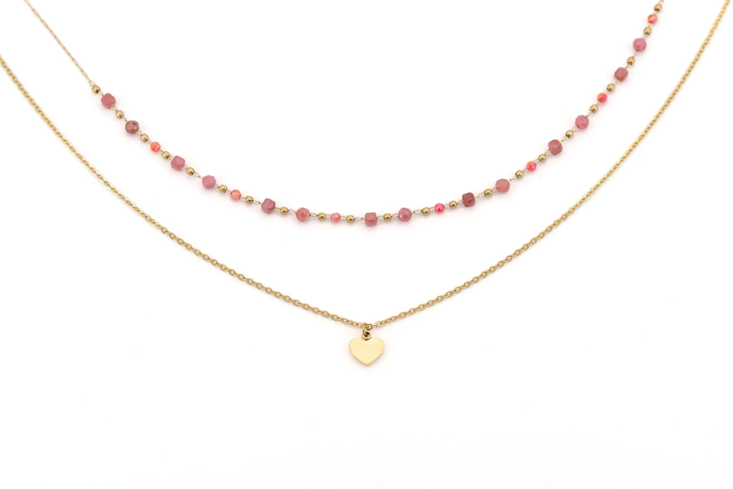 Layered gold necklace with pink beads and heart pendant on white background