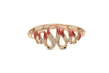 Gold serpentine bracelet with wavy pink enamel accents on white background